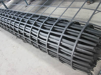 A roll of black color steel plastic composite mine supporting mesh on the ground.