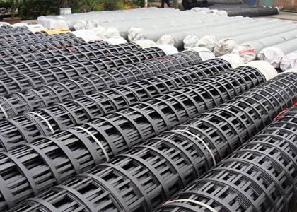 Many rolls of steel plastic geogrids on the ground.